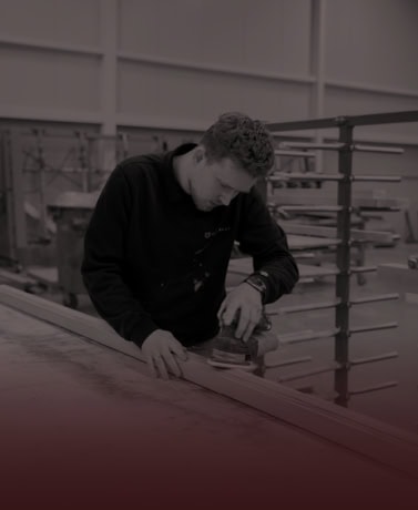 Vakman werkt aan houten trap in productieatelier bij Stairlux.